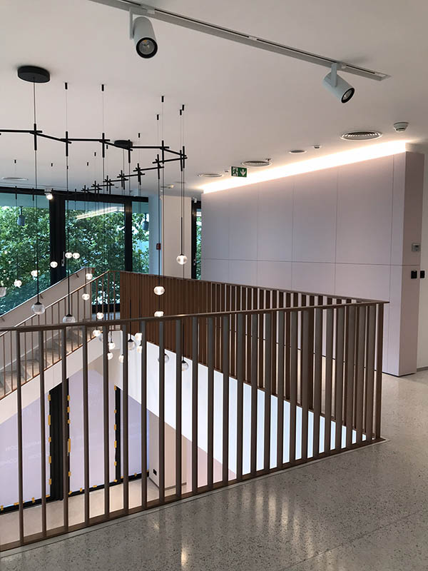 Hotové interiérové schodisko so zábradlím vo farbe medenej patiny pri pohľade na zábradlie galérie | DOMO GLASS