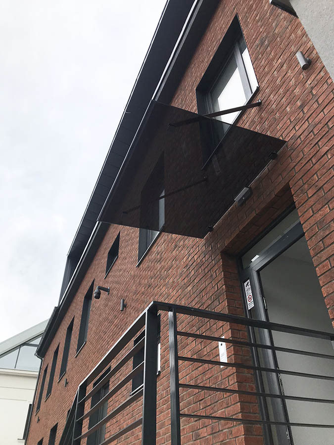 Sklenená markíza s čiernym bezpečnostným sklo ukotvená pomocou načierno lakovaných tiahel | DOMO GLASS